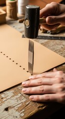 Artisan uses a mallet and punching tool to create precise holes in a piece of light brown material.