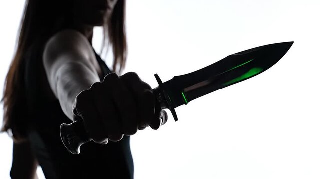 Silhouette of woman holding knife