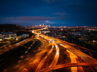 Aerial night view of Turcot Interchange in Montreal with glowing highways and city lights at dramatic blue hour. g
