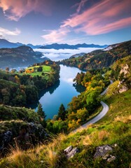 Winding road beside a lake surrounded by autumn trees and mountains