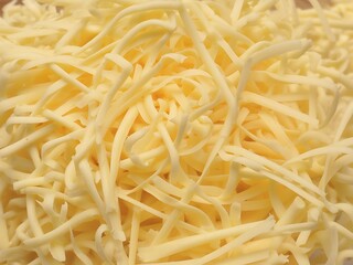 Fototapeta premium A close up macro of shredded cheese on a white background dairy food