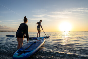 Young people having fun, enjoying their vacations outdoors at the beach with surfboards. Sport, surf