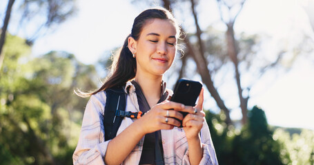 Naklejka premium Phone, navigation and woman in nature for hiking, space and guide in path direction. Travel, bokeh and female person in forest with tech, map tracking and location search on outdoor adventure.