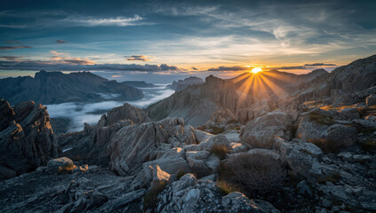 Obraz premium Sunrise mountain rock landscape with sunburst and low cloud filling valley