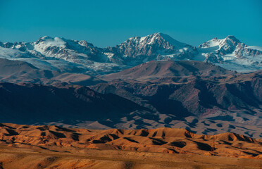 Snowy mountains and hills of Kyrgyzstan at sunset