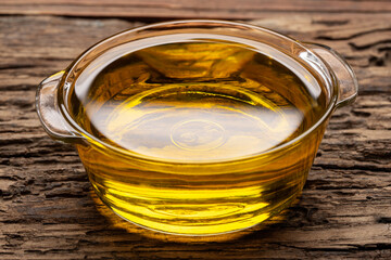 Glass bowl filled with olive oil on a wooden table