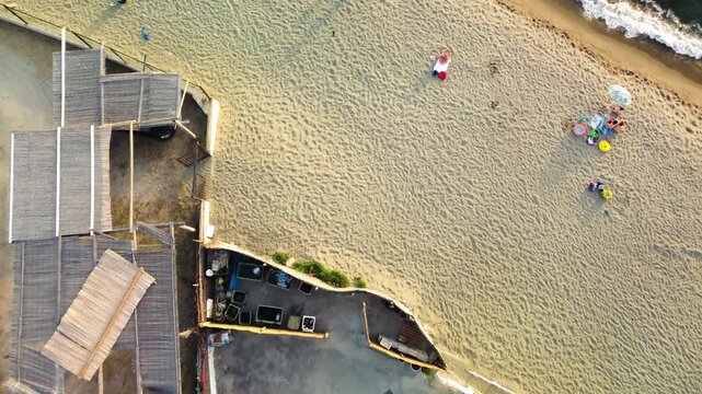 Overhead aerial view of Ischia Citara Beach at sunset with pools and sand