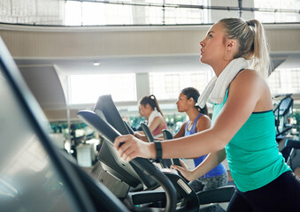 Fototapeta premium Gym, fitness and woman on machine, breathing and workout routine for health goal, practice or cardio. Training, person and exercise with elliptical equipment for wellness, active and burning calories