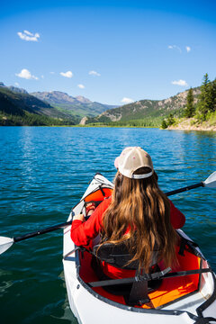 Woman exploring Colorado mountain lake by kayak