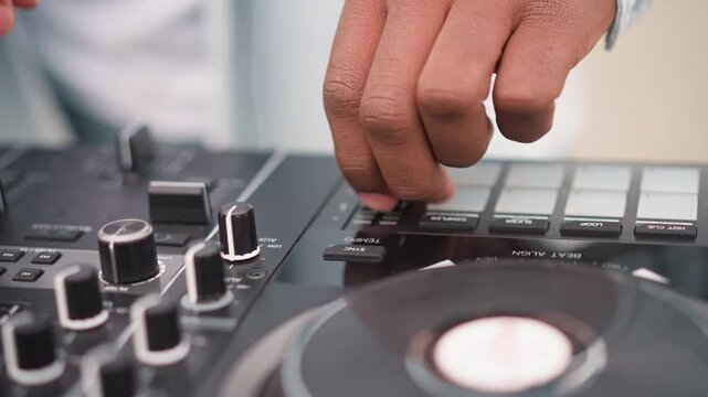black DJ hands on controller mixing, closeup of fingers adjusting fader and knob, vinyl jogwheel spinning, pad trigger and cue button action, urban street setup with energetic rhythm, tactile