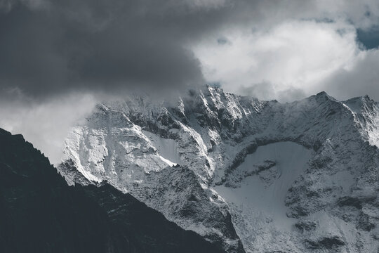 snow covered mountains in winter with low dark clouds