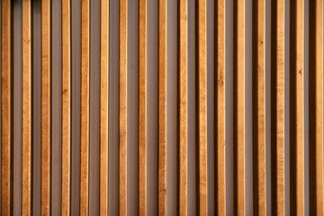 Obraz premium A beautifully crafted wall of vertical wooden slats fills the interior, casting soft shadows and enhancing the warmth of the space. The natural hues invite tranquility and style.