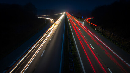 Vibrant long exposure captures car light trails on a modern highway at night, illustrating speed, urban infrastructure, and the dynamic flow of modern travel and connectivity.