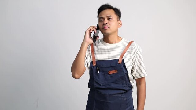 Restaurant or coffee shop waiters wearing aprons communicate and take customer orders via telephone.