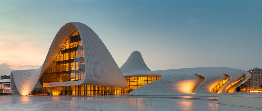 Baku, Azerbaijan - November 5, 2024: Heydar Aliyev Center's iconic fluid architecture illuminated at dusk, showcasing its modern design against a twilight sky