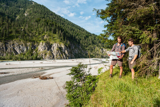 Brothers hiking outdoors by mountain river in summer nature