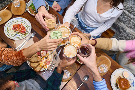 Group toasting drinks at brunch table celebrating togetherness