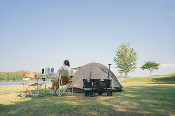 asian couple fun happy and relax with camping and picnic at side of lake with mountain background