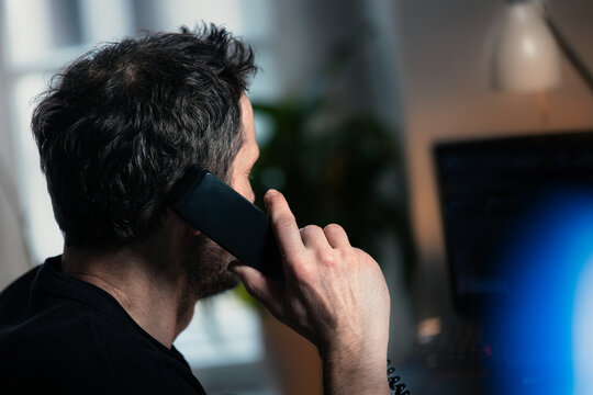 Mann telefoniert im B&uuml;ro an seinem Arbeitsplatz