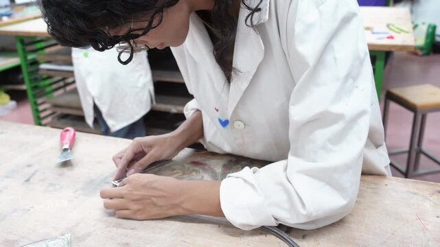 Artisan shaping lead came for stained glass art project