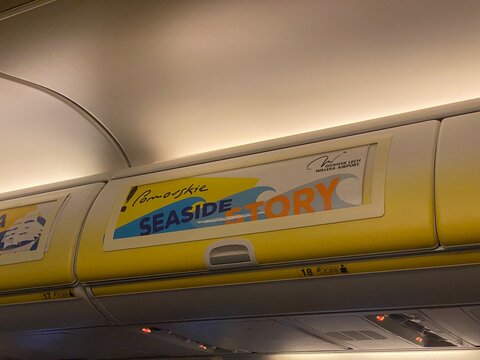 Palma, spain, january 20, 2026, airplane overhead compartment displaying advert for pomorskie seaside story and gdansk lech walesa airport