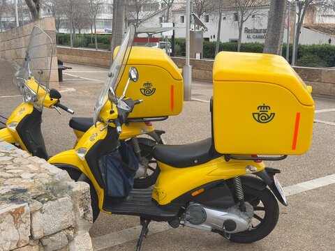 Palma, spain, january 20, 2026, yellow correos scooters parked on a street, providing postal and mail delivery service in spain