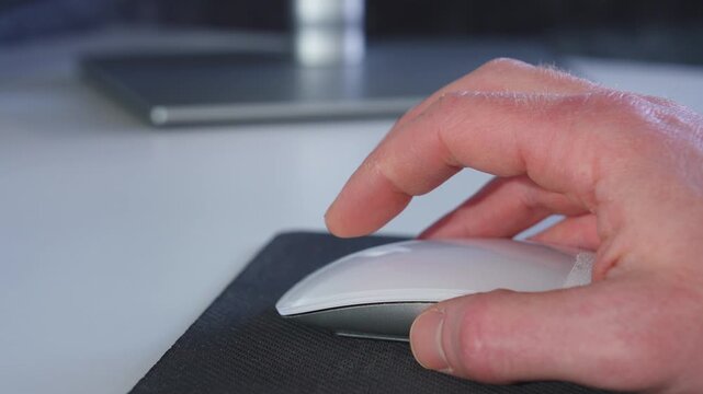 Hand scrolling and clicking with computer mouse at modern desk