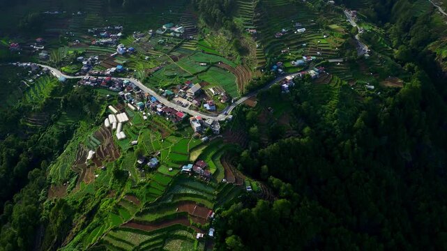 Oblique angle aerial motion over Halsema Highway Atok Benguet Philippines highlighting winding roads and cultivated vegetable fields