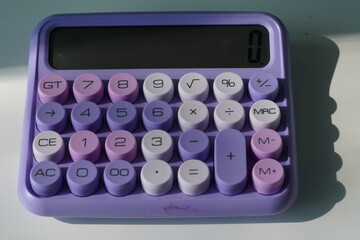 Stylish purple pastel calculator on a desk, modern office stationery.