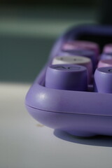 Stylish purple pastel calculator on a desk, modern office stationery.