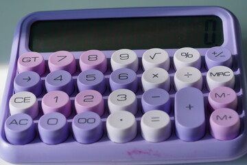 Stylish purple pastel calculator on a desk, modern office stationery.
