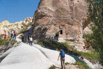 Obraz premium Group of hikers with backpacks exploring the rocky valleys and caves of Cappadocia, Turkey