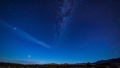 Starry Night Sky with Milky Way and Meteor Shower Over Dark Landscape