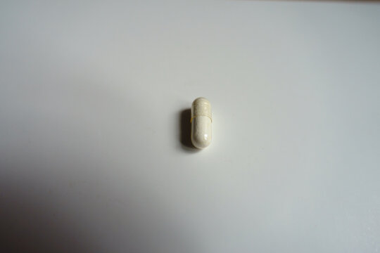 1 white capsule of melatonin dietary supplement