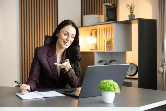 A cheerful woman shares her ideas during a virtual call, radiating positivity and professionalism.