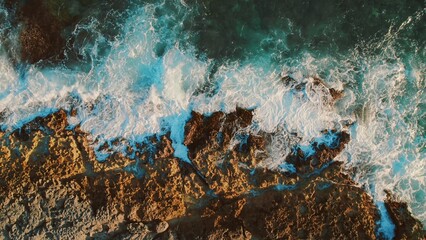 Waves breaking on rocky shore with turquoise sea at Crocodile Lagoon in Mexico. © Olga Gorkun