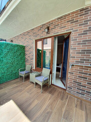 Naklejka premium Outdoor Terrace with Wicker Furniture near Brick House
