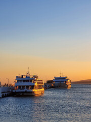 Fototapeta premium Passenger Ferries Docked in Golden Sunset Light