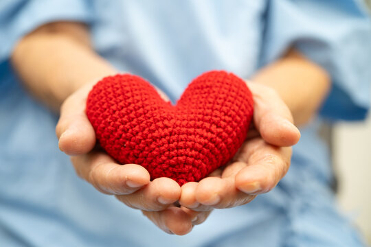 Doctor holding a red heart in hospital, healthy strong medical concept.