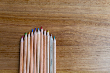 Obraz premium colorful wooden pencils arranged neatly on wooden table, symbolizing creativity, education, art supplies, and design tools for school, office, or artistic inspiration.