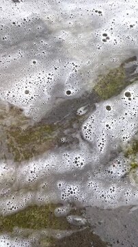 Water with foam flows down the concrete surface