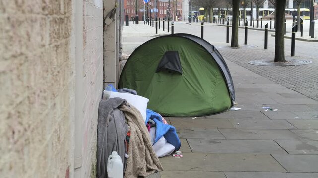 Homeless person tent on a dirty city pavement