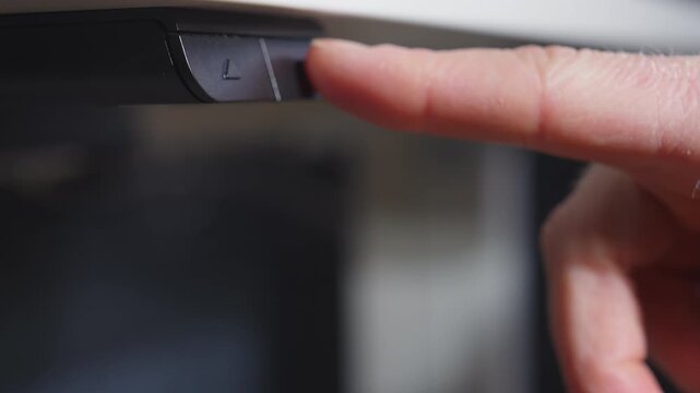 Finger pressing button to lower adjustable standing desk