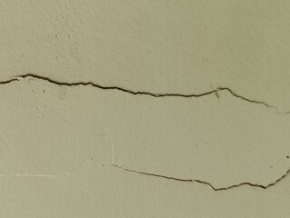 Macro Texture of Cracked Concrete Wall - Detailed View of Horizontal Fissures and Fractures on an Aged Pale Green Plaster Surface