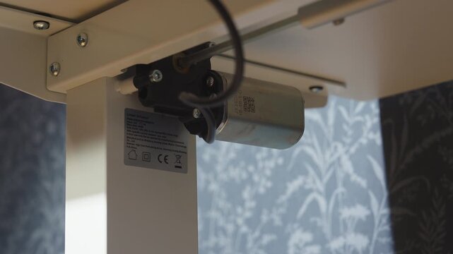 Motor operating under adjustable standing desk during height adjustment