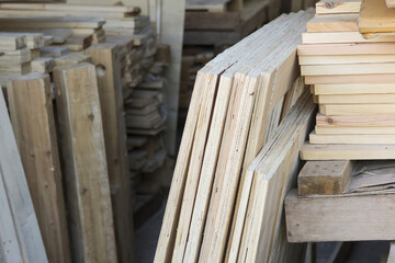 Large stack of wooden planks and raw timber beams stored carpentry workshop waiting for industrial construction project or renovation with rustic texture and natural grain pattern of plywood