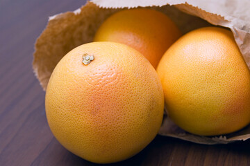 pink grapefruits in a paper bag on the table