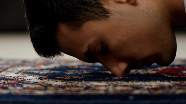 Close up of a man in prostration during Islamic prayer. Muslim man performing Sujud on a prayer rug. Concept of faith, devotion, and religious worship