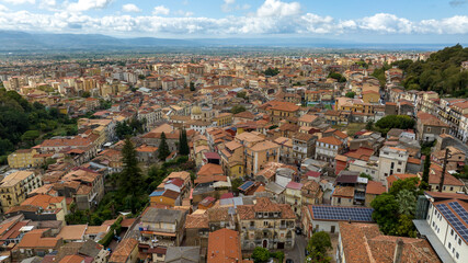 Fototapeta premium Aerial view of the town of Lamezia Terme, in the province of Catanzaro, Calabria, Italy. In the foreground, the houses of the historic center. In background, the Calabrian coast of the Tyrrhenian sea.