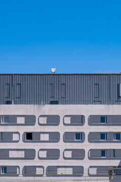 Modern minimal office building facade with windows forming a grid pattern against clear sky for corporate architecture and abstract geometry